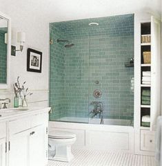 a bathroom with green tiles and white fixtures