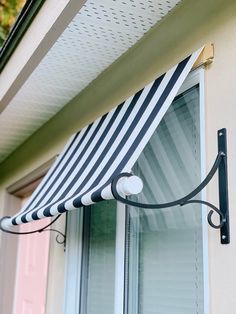 an awning hanging from the side of a house next to a window sill