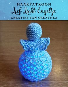 a crocheted blue bird sitting on top of a wooden table