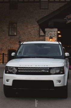 a white range rover parked in front of a building