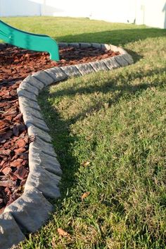 a green slide sitting in the middle of a yard