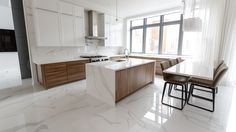 a kitchen with white marble counter tops and wooden cabinets