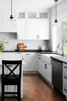 a kitchen with white cabinets and black chairs