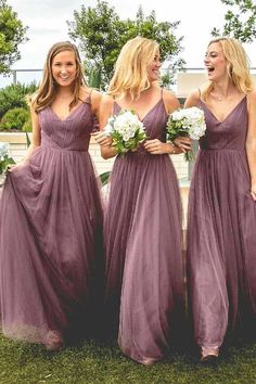 three beautiful women in long purple dresses standing next to each other and smiling at the camera