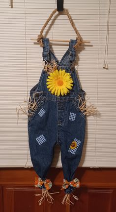 a pair of blue overalls with a yellow flower attached to the back of it