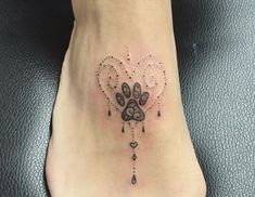 a dog's paw and heart tattoo on the foot