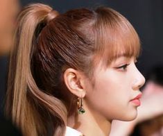 a woman with long hair in a ponytail and wearing earrings on her head, looking off to the side