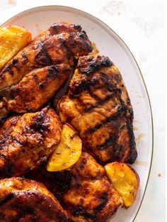 grilled chicken with lemons and potatoes on a plate