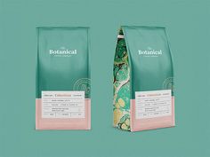 two bags of coffee sitting next to each other on a green background with a pink tie