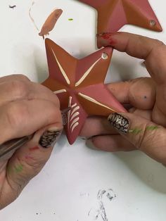 two hands are working on a star decoration