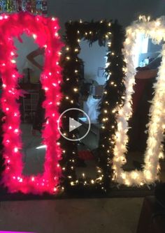 two mirrors decorated with lights and garlands in the shape of letters i - u