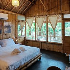 a bed in a room with wooden walls and windows