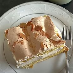 a piece of cake sitting on top of a white plate next to a fork and cup