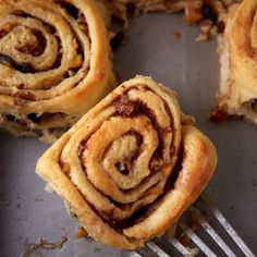 several cinnamon rolls on a plate with a fork