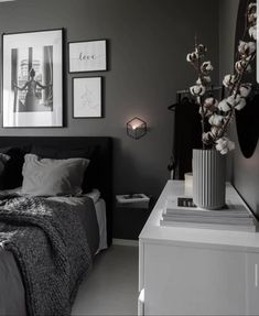 a black and white bedroom with pictures on the wall