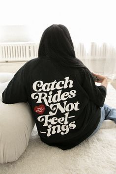 a woman is sitting on the floor with her back to the camera and reading a book