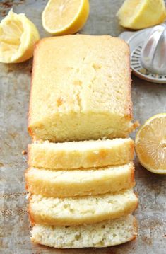 slices of lemon pound cake sitting on top of a baking sheet next to sliced lemons