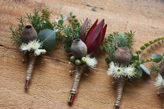 the flowers are arranged on the wooden board with buds and leaves in them for decoration