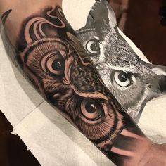 an owl and wolf tattoo on the left arm, both with different eyes in black and grey