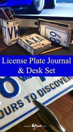 the license plate journal and desk set is on display in front of a blue car