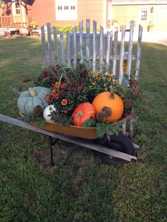 a wheelbarrow filled with pumpkins and gourds