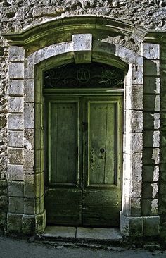 an old stone building with a green door