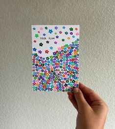 someone holding up a card with colorful flowers on it