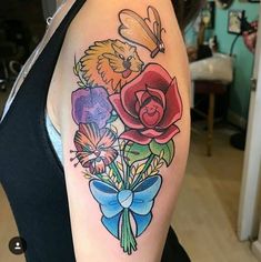 a woman's arm with flowers and a bird on it, in the middle of her arm