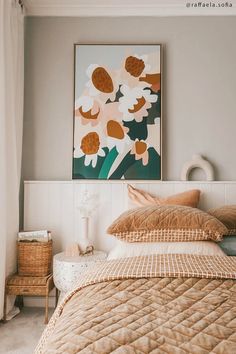 a bed sitting in a bedroom next to a large painting on the wall above it