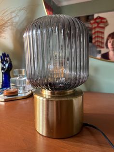 a glass lamp sitting on top of a wooden table