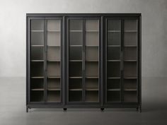 an empty bookcase with glass doors on the front and side, against a gray wall