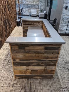 a counter made out of pallet wood in a room with brick walls and flooring