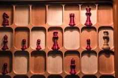 a wooden box filled with red and white chess pieces on top of eachother