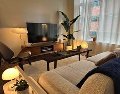 a living room filled with furniture and a flat screen tv on top of a wooden stand