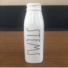 a white glass bottle sitting on top of a wooden table