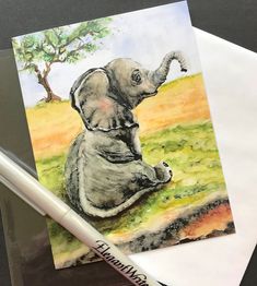 an elephant is sitting on the ground next to some watercolor pencils