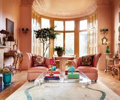 a living room filled with furniture and a fire place next to a large round window