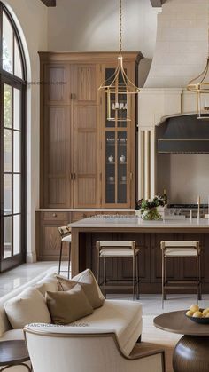 a living room filled with furniture next to a kitchen