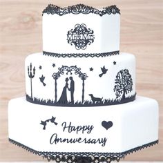 a wedding cake decorated with black and white designs on it's sides, featuring the bride and groom