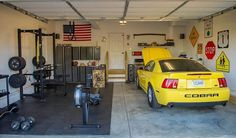 a yellow car is parked in a garage with other cars and equipment on the wall