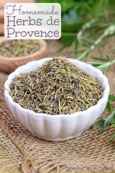 some herbs are in a white bowl on a table