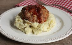 a white plate topped with mashed potatoes and meat