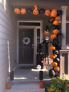 a front porch decorated for halloween with pumpkins and jack o lanterns