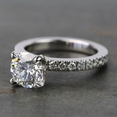 an engagement ring with a diamond on the side and a channeled band around it