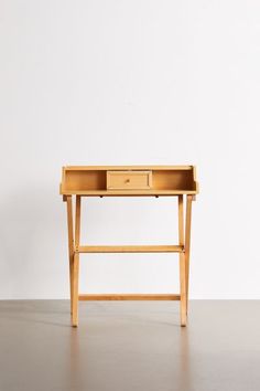 a small wooden desk with two drawers on one side and an open drawer on the other