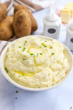 mashed potatoes in a white bowl with butter and parsley