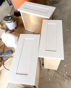 two white cabinet doors sitting next to each other on top of plywood planks