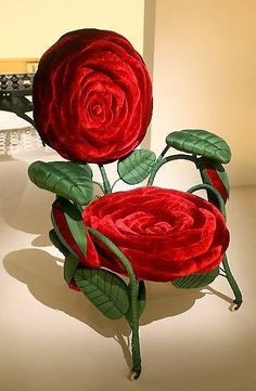 two red roses sitting on top of each other in the middle of a white room