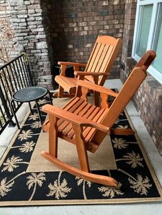 two wooden rocking chairs sitting on top of a rug next to a black table and chair