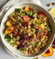 a white bowl filled with lots of different types of food on top of a table